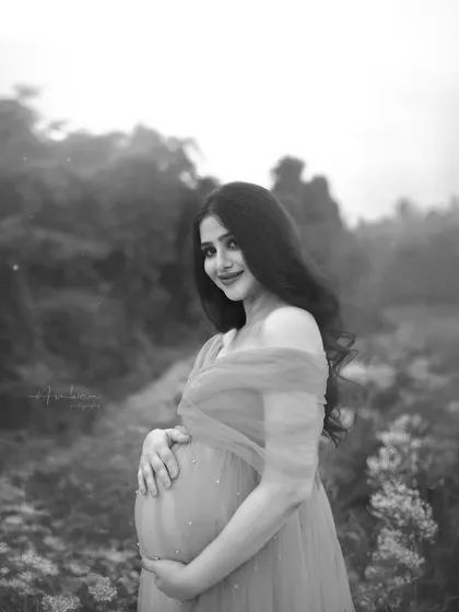 The black and white version of the outdoor portrait, which adds a timeless and classic feel. The monochrome edit emphasizes her serene expression and the soft textures of the gown.