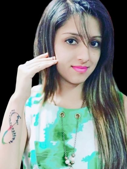 A client showing her colorful infinity feather tattoo on her arm.