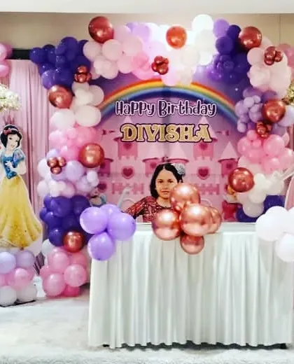 An enchanting princess party setup featuring cherry blossom trees, a castle backdrop, and cutouts of Snow White, Aurora, and other princesses for a magical 5th birthday.