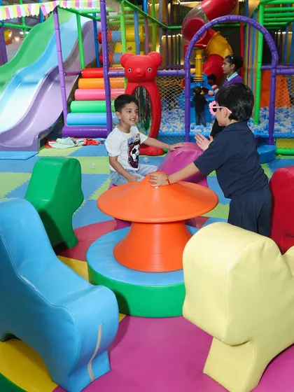 Friends playing together on the soft merry-go-round in our dedicated toddler section.