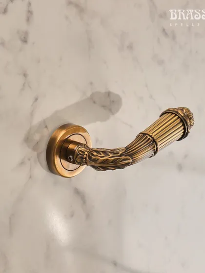A close-up of the Mumtaz lever handle, highlighting the fine, reeded texture and floral-inspired carving.