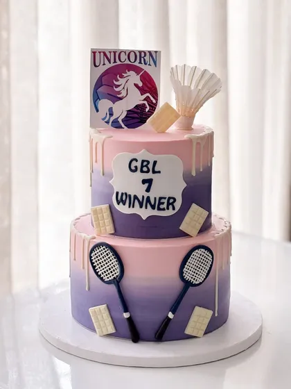 Victory never tasted so sweet! A two-tiered badminton theme cake to celebrate the winners of a tournament, with colors matching the team's unicorn logo.