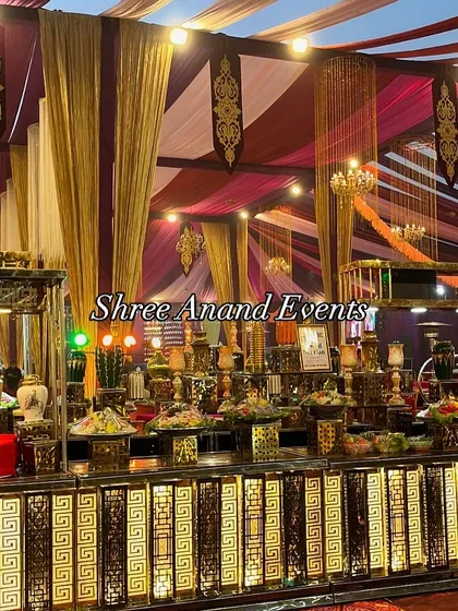 An expansive and richly decorated buffet station under a colorful tent. The counter is filled with a vast array of dishes, showcasing the abundance and variety I bring to every wedding feast.