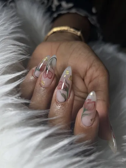 This is an example of soft, elegant nail art perfect for a minimalist bride. The delicate, hand-painted flowers on long, clear stiletto extensions with a hint of gold foil add a touch of romance without being overpowering.