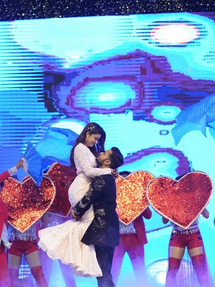 A classic romantic pose during the couple's Sangeet performance, with dancers holding heart-shaped props. I choreograph and design these picture-perfect moments.
