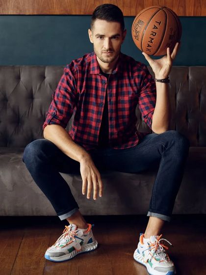 A full-length shot of the casual plaid shirt and denim look for Basics Life. The colorful sneakers add a modern, playful touch to the classic outfit, showing how we use accessories to complete a look.