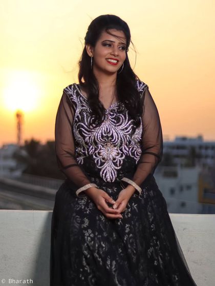 A smiling portrait taken on a rooftop at sunset. The warm, golden light gives the skin a beautiful glow.