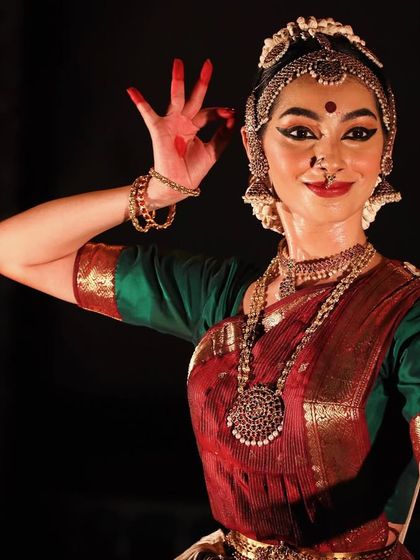 A close-up shot from a performance, highlighting the 'hasta' or hand gesture, which is a key element of storytelling in Bharatanatyam. Every detail, from the fingertips to the facial expression, matters.