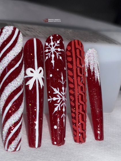 Winter special alert! These classic red Christmas nails feature candy cane stripes, a gift bow, and snowflake designs.