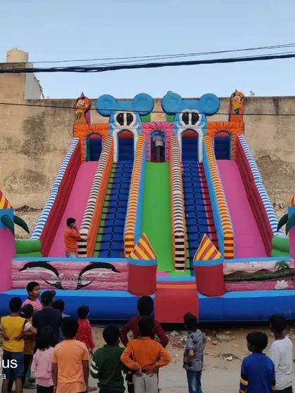 A large multi-slide bouncy set up for a community gathering, showing its capacity to entertain many children at once.