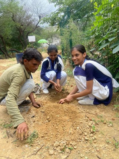 A student and our on-ground team member work together to plant a sapling during a plantation drive with Quota International.