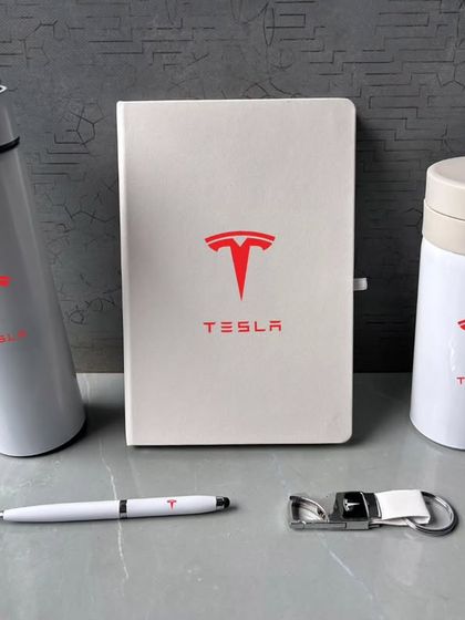 Another view of the white Tesla gift set, showing the items arranged neatly. The consistent branding and color scheme make it a very impactful corporate gift.