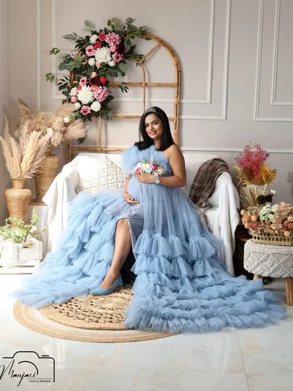 A serene and beautiful portrait, holding a small bouquet that complements the floral belt on her gown.