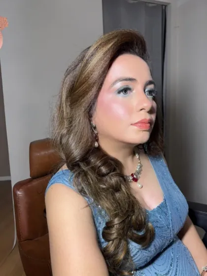 Another angle of the elegant blue gown look. The soft curls in her hair and the radiant makeup come together to create a look of pure sophistication.
