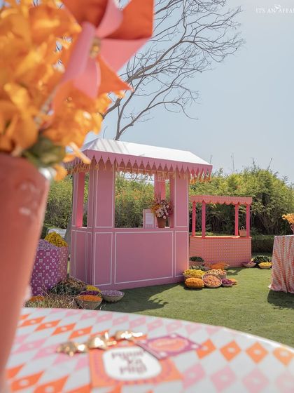 A view across a patterned tabletop towards a pink stall in the distance, showcasing the layers and depth of the event design.