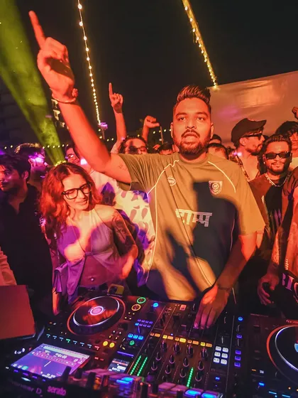 In the zone during a packed club night. This is a classic shot of me connecting with the audience, hands up, feeling the music together. It's all about that shared energy.