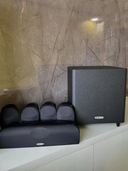 The Polk Audio TL1600 is a complete 5.1 channel home theater speaker package. It includes four satellite speakers, a center channel, and a powered subwoofer for a compact yet powerful surround sound experience.