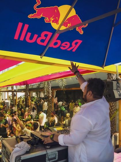 Performing under the iconic Red Bull umbrella at a sundowner Holi party. I bring the festival energy to any setting, big or small.