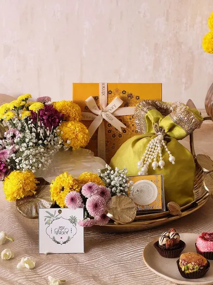The Lotus Marigold Tray is designed for traditional elegance. It features an Urli candle, sugar-free mithai, and honey choco almonds, making it a perfect centerpiece for Diwali celebrations.