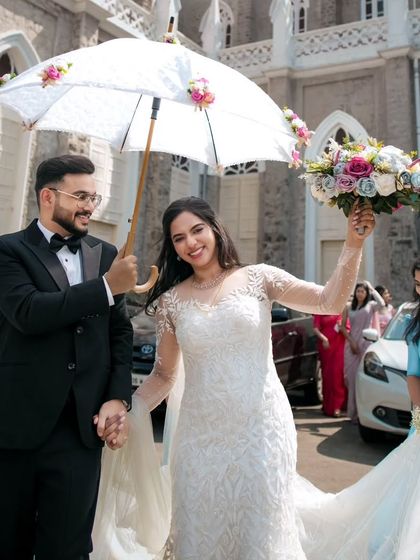 A joyful exit from the church. This happy couple is all smiles, with the groom looking dapper in his classic wedding attire.