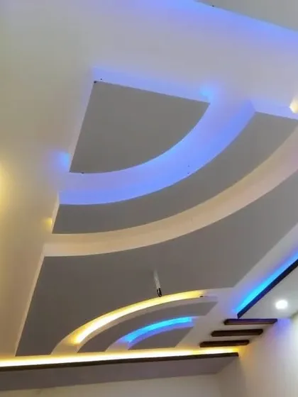 This design uses yellow and blue lights to trace the elegant curves of the ceiling. The dark wood-finished beams add a nice contrast.