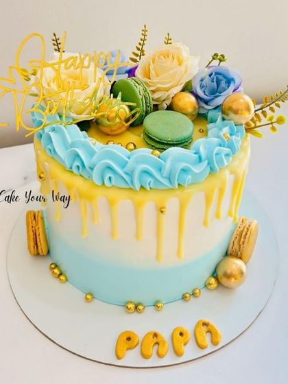 A masterpiece for Papa's birthday, this drip cake is topped with macarons and fresh flowers.