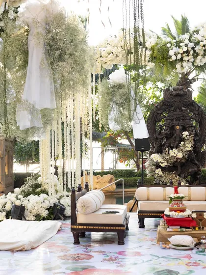 Set against a serene poolside, this mandap is a study in timeless elegance. I combined a profusion of classic white florals and fresh greenery with the divine presence of a Ganesha sculpture, creating a space that feels both sacred and seamlessly integrated with nature. This design showcases my ability to craft sophisticated outdoor ceremonies.