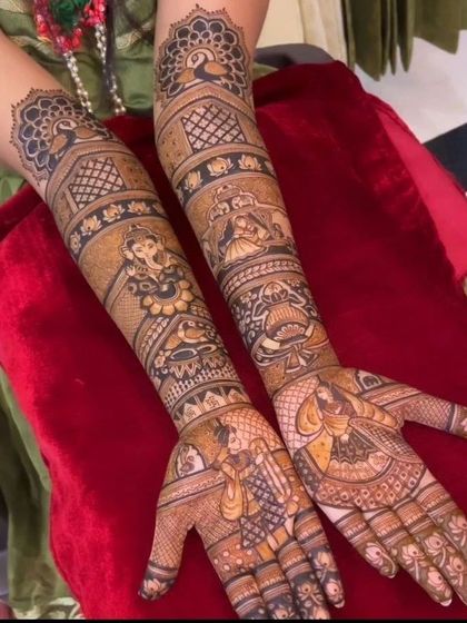 A beautiful design featuring Ganesha and other deities, with intricate patterns filling the arms up to the elbow.