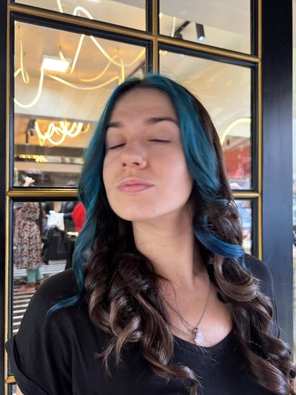 Feeling the vibe with her new blue highlights. This look is all about self-expression, and the vibrant blue against the dark base color creates a stunning contrast.