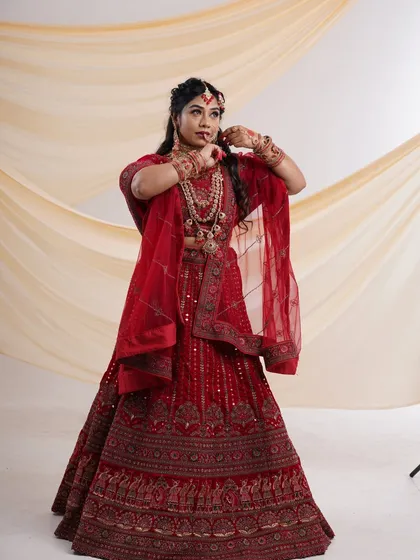A stunning red bridal lehenga, available for rent. This shot captures the intricate details and rich color, perfect for a bride's big day or a pre-wedding shoot.