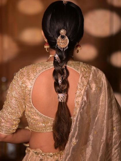 A close-up of the traditional braid, showing the intricate details of the hair accessory and the neatness of the plait.
