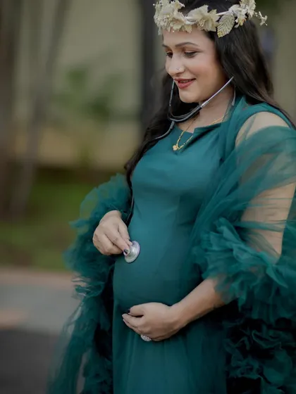 A close-up of a mom-to-be, who is also a doctor, using a stethoscope on her belly. A wonderful way to blend her profession and her pregnancy.