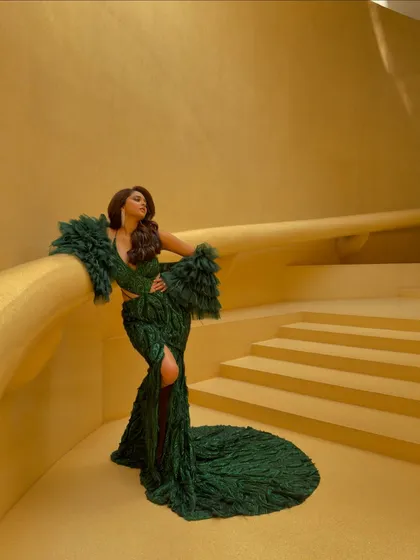This emerald green gown by Amit GT features dramatic ruffled sleeves and a thigh-high slit. It's a perfect example of the powerful, high-fashion cocktail looks I curate for my clients.