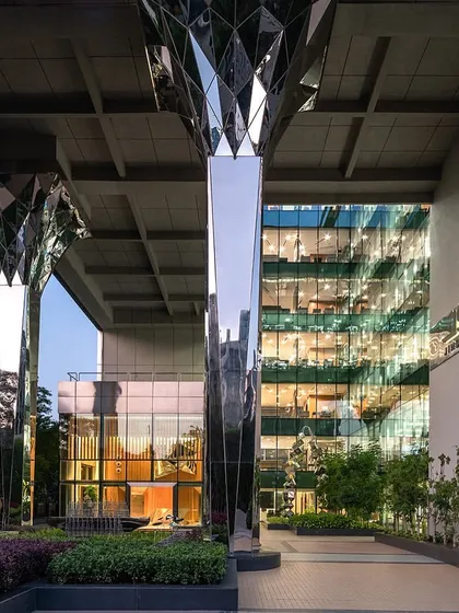 The entrance courtyard of the Stainless Steel Office, where our faceted steel columns frame the main entrance, demonstrating how we integrate bold architectural features with landscape design.