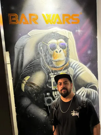 Posing in front of a 'Bar Wars' mural. The force is strong with this one.