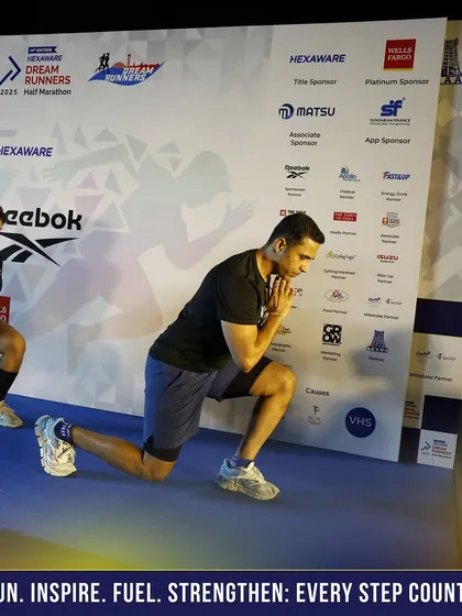 Demonstrating a lunge stretch on stage. A proper warm-up is essential for a good race.