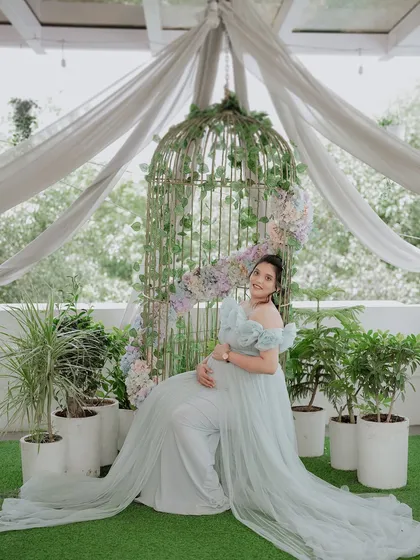 A serene moment captured in our light blue Isabella gown. The long, flowing trail and off-shoulder ruffles create a soft and elegant silhouette, perfect for outdoor garden shoots.