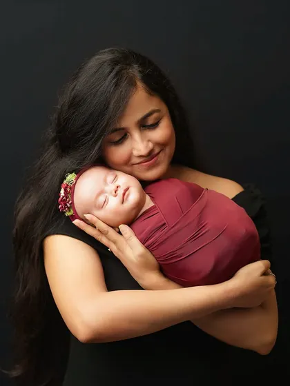 A mother's gentle embrace. This portrait of a mom holding her newborn daughter close to her heart is a timeless expression of maternal love.