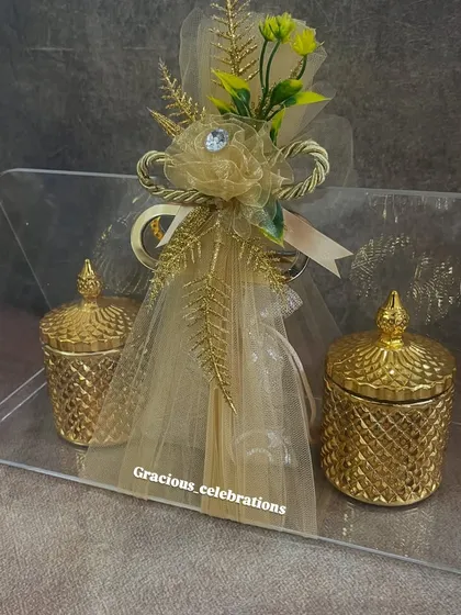 A luxurious wedding favor option, this acrylic bag holds two golden crystal jars and a central potli. The potli can be filled with chocolates or replaced with one of our handmade scented candles.