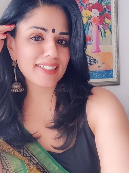 A close-up showing the combination of the yellow Kota Doriya saree, a simple black bindi, and silver jhumkas. This is a classic look that never goes out of style.