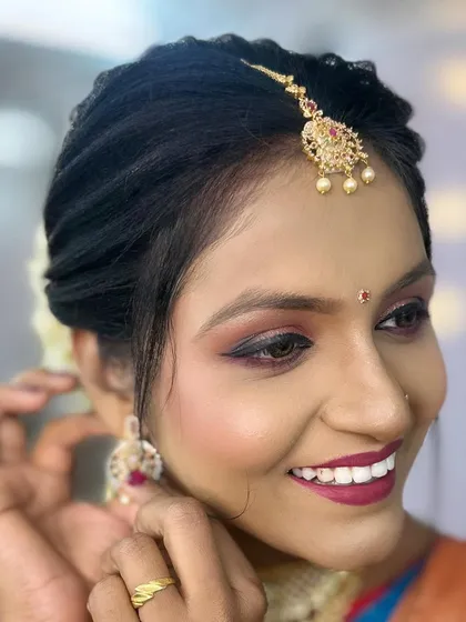 A detailed close-up of the eye makeup and the traditional maang tikka.
