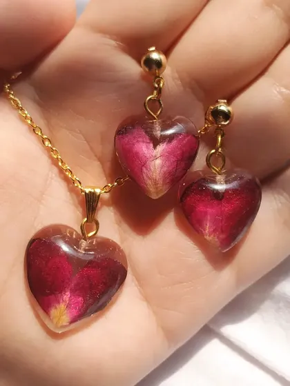 I can turn your memorable flowers into a beautiful jewelry set you can wear. This heart-shaped necklace and matching earrings were made by preserving delicate rose petals in resin, creating a personal and romantic accessory.