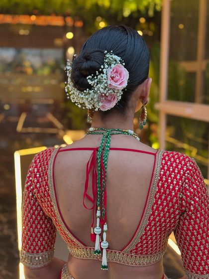For this bride's look, I combined delicate pink roses with baby's breath to create a soft floral halo around her sleek bun. This style adds a touch of romance and is perfect for coordinating with the colors in a bridal lehenga.
