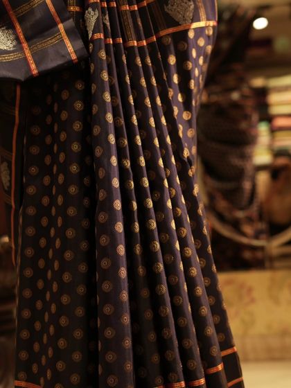 The graceful fall of the navy blue Kanjivaram, showing how the different patterns create a dynamic and modern look.