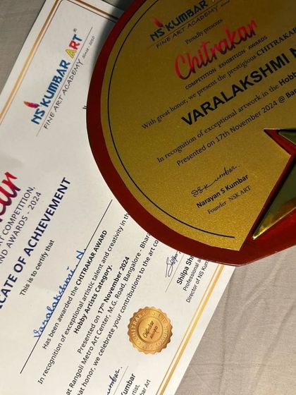 A proud moment for our student Varalakshmi N, receiving her Chitrakar Award certificate and trophy. We celebrate every student's contribution to the art community.