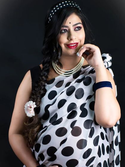 A stylish and classic portrait in a polka dot saree. The mom-to-be's pose and expression evoke a sense of vintage glamour and fun.