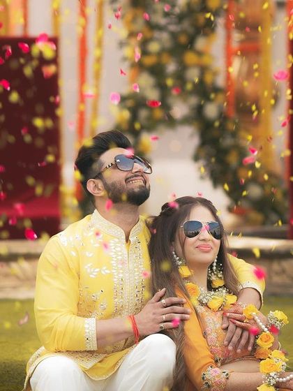 Another beautiful shot of Akhilesh and Nisha under a rain of petals, looking up with joy and anticipation.