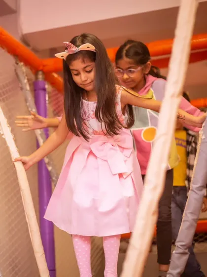 Carefully navigating the rope bridge in our play structure. It's a fun challenge for adventurous kids.