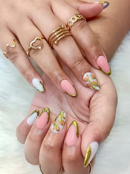 A different view of the hand-painted gold leaf nails, showcasing the beautiful contrast between the pink, white, and gold.