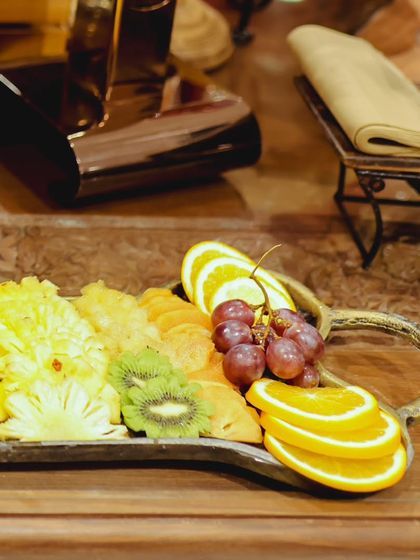 Another angle of the fresh fruit platter, highlighting the mix of tropical fruits like pineapple and kiwi alongside grapes and oranges.